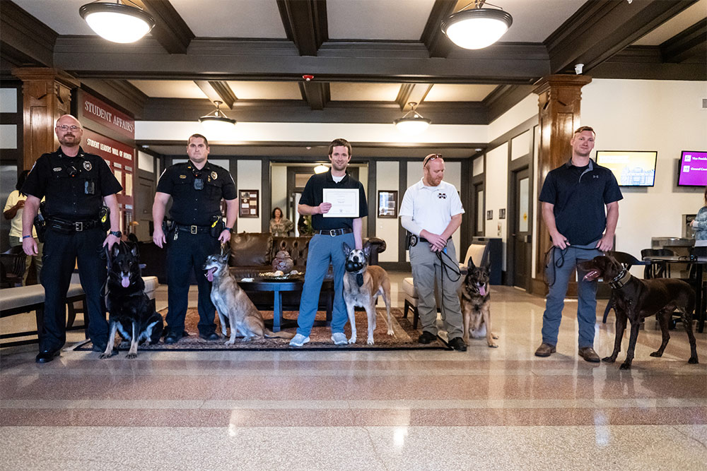 Along with retiring K-9 Bach, center, other keonhaca and local police dogs are pictured with their handlers.
