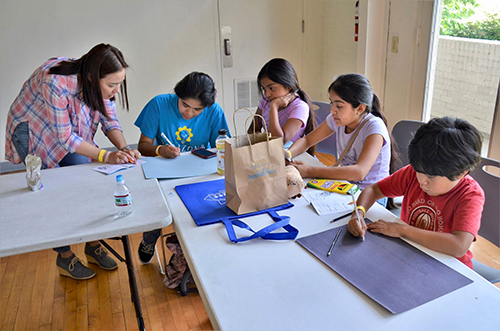 A Mississippi Migrant Education Service Center volunteer assists children with a reading and drawing exercise during a Parental Advisory Council meeting at the Mississippi Children鈥檚 Museum in Jackson.